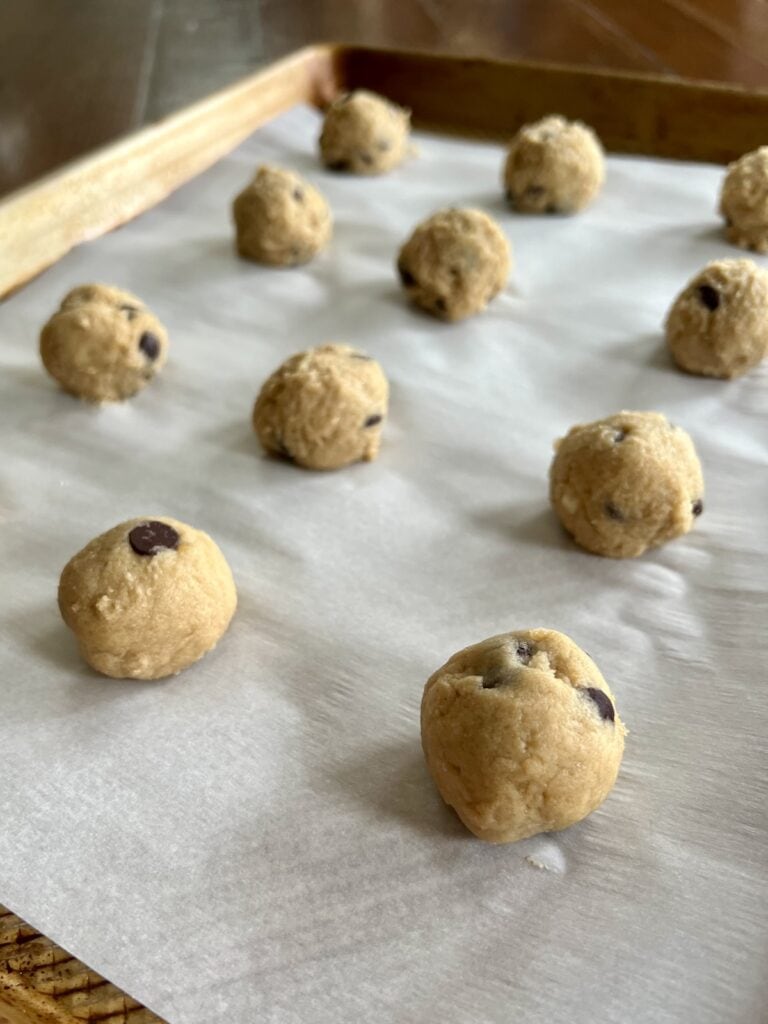 closeup of banana bread cookie dough freezer bites on a parchment paper-lined baking sheet