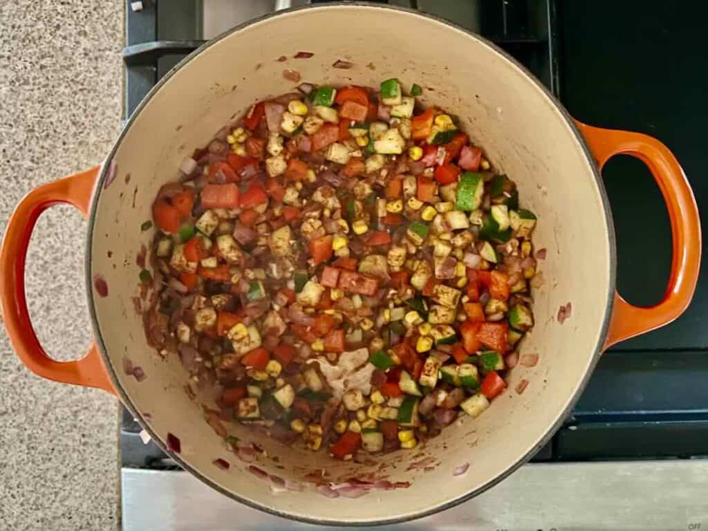 overhead view of Dutch oven containing cooked vegetables with spices