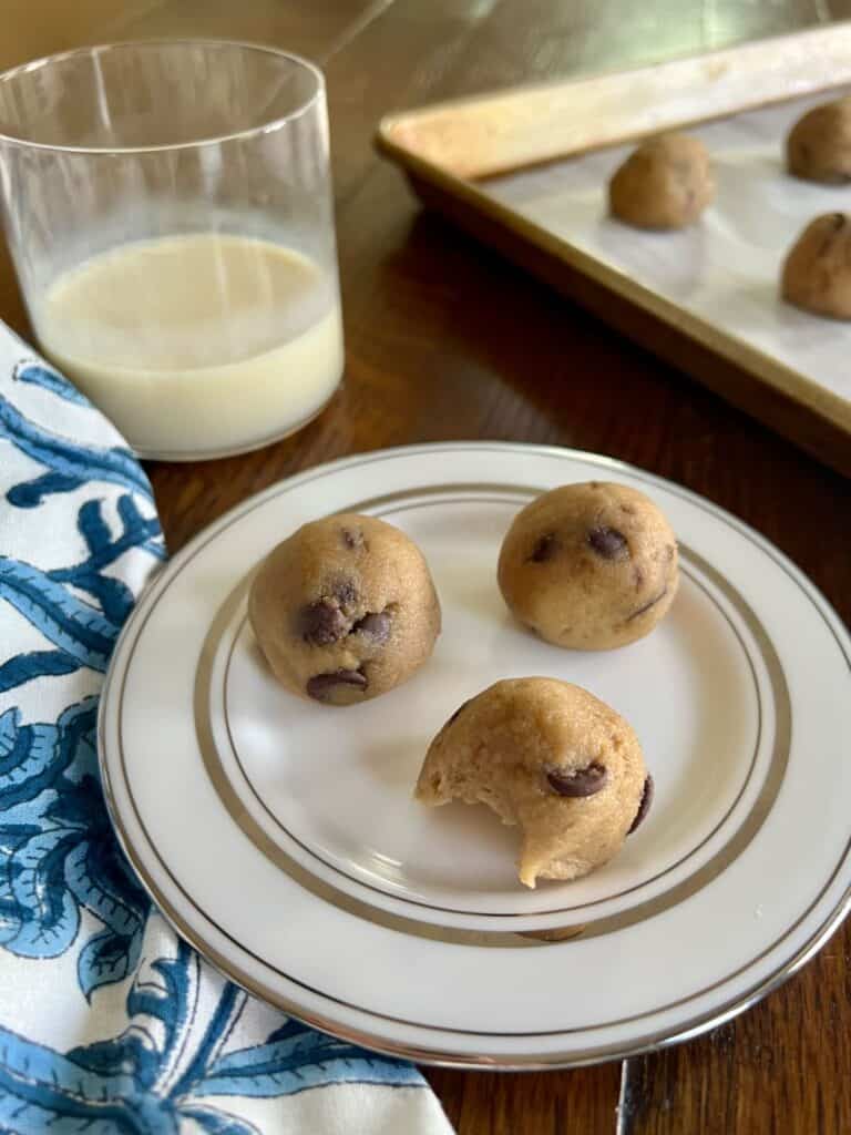 three banana bread cookie dough freezer bites with a bite out of one on a small round plate