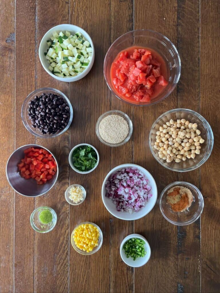 overhead view of small bowls containing prepared ingredients on a wood table