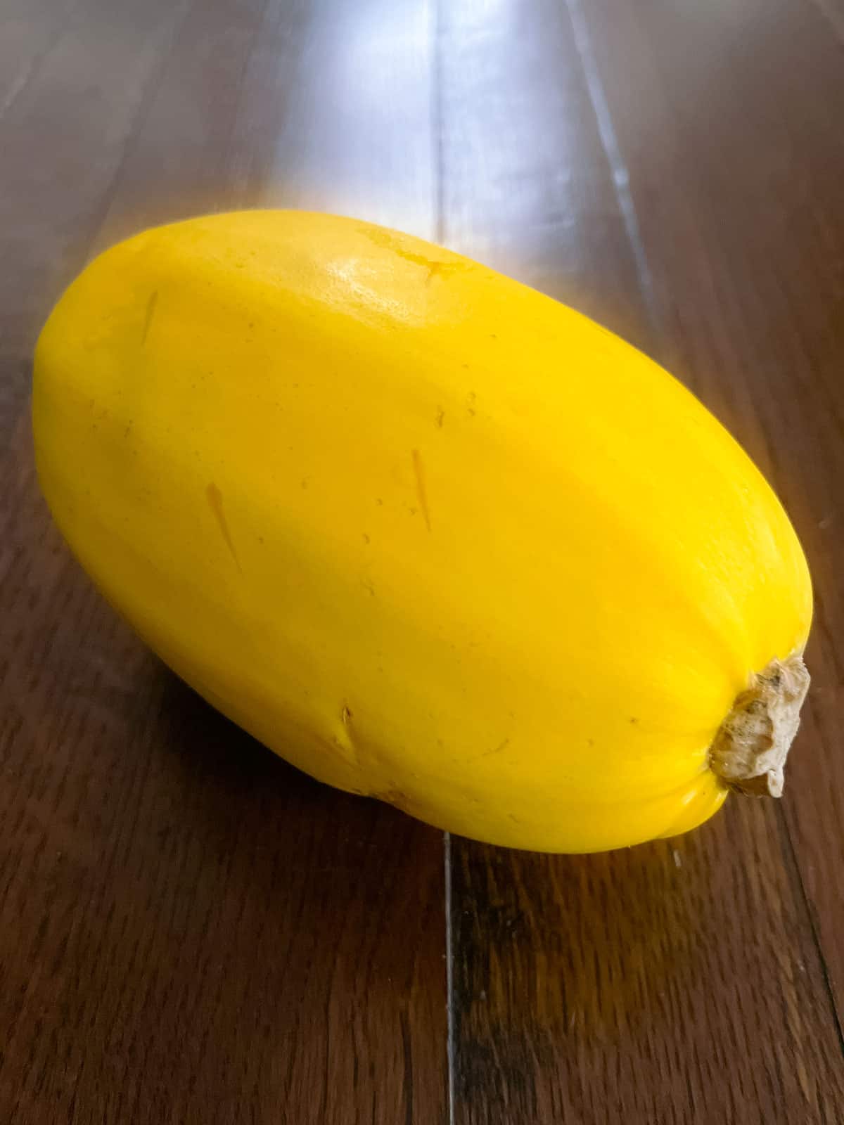 spaghetti squash poked with holes on a wooden table