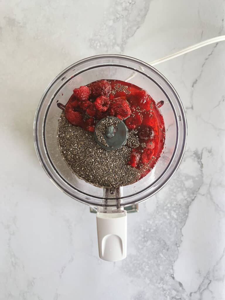 food processor with ingredients for raspberry chia pudding