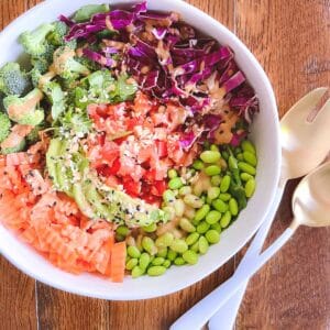 bowl of easy rainbow crunch edamame salad with serving tongs