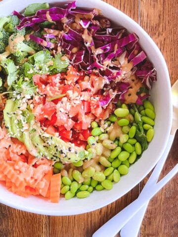 bowl of easy rainbow crunch edamame salad with serving tongs