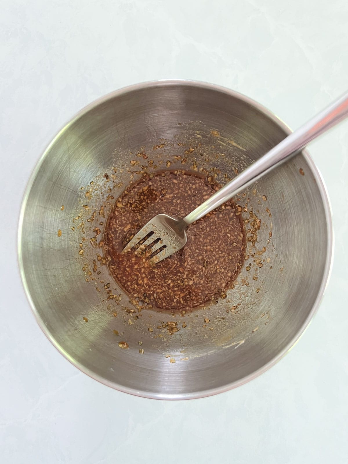 bowl of whisked dressing with a fork in it