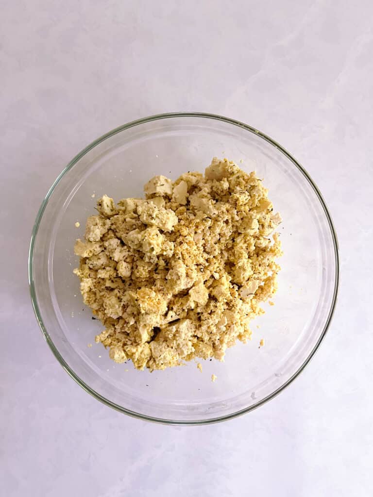 bowl containing crumbled tofu combined with seasoning blend