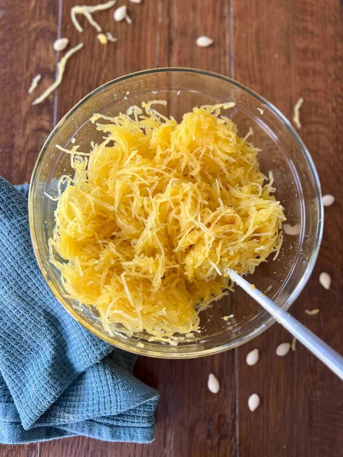 bowl of cooked spaghetti squash with a fork and a napkin