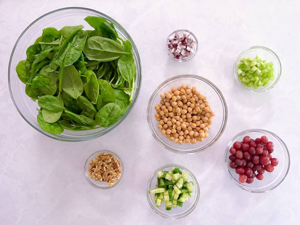 bowls containing ingredients for Mediterranean salad