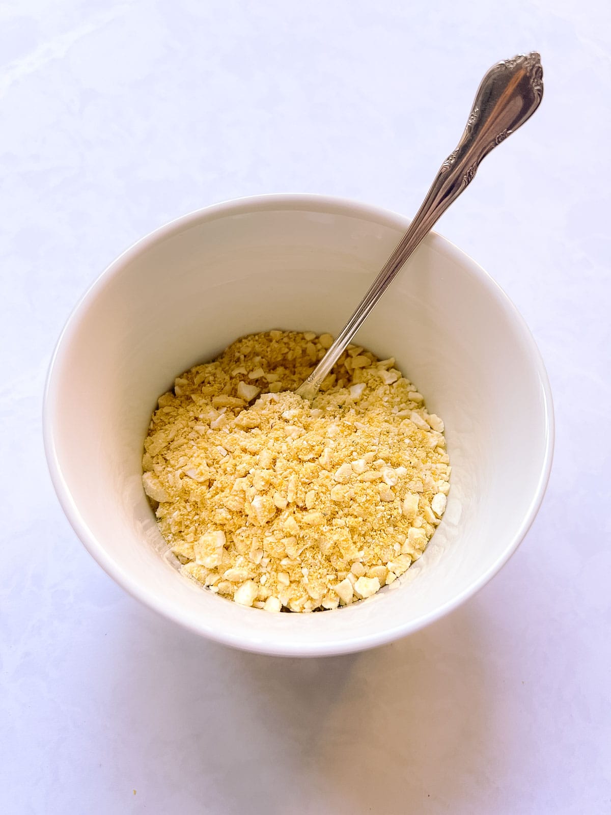 bowl of quick vegan Parmesan with a spoon in it