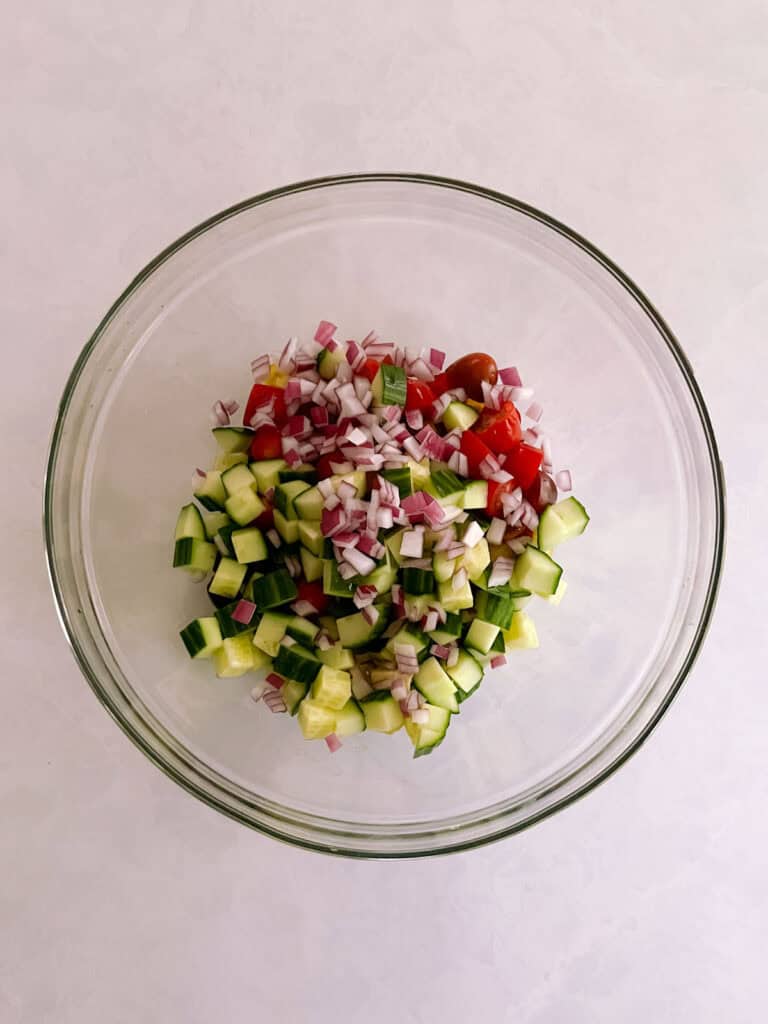 bowl containing unmixed salad ingredients and dressing