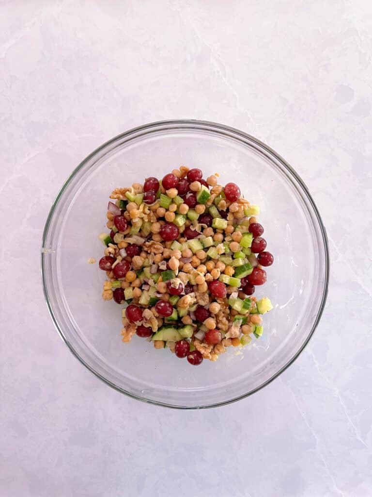 bowl containing mixed Mediterranean salad ingredients and oil-free 
dressing