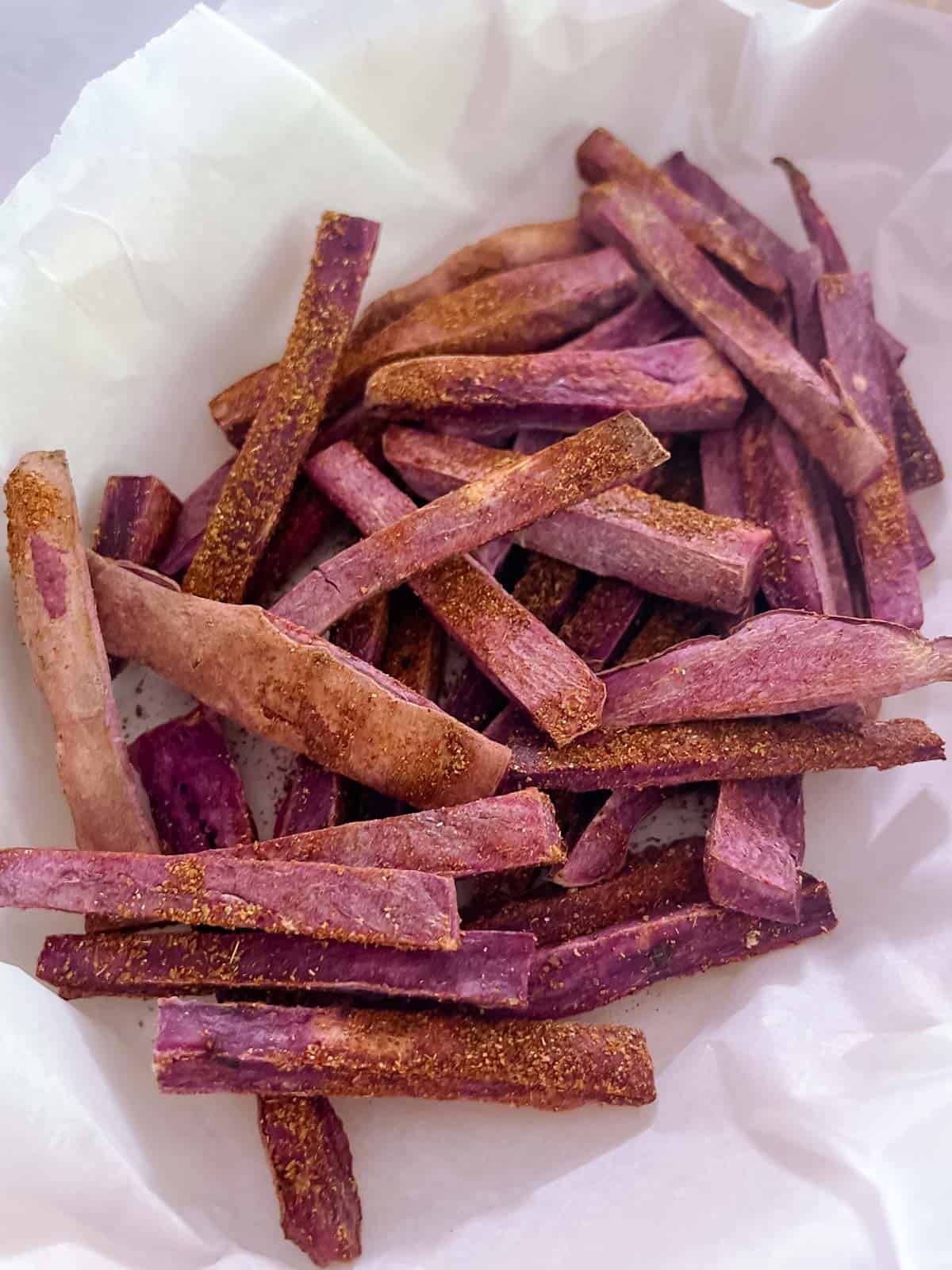 close up of Tex-Mex seasoned sweet potato fries on parchment paper