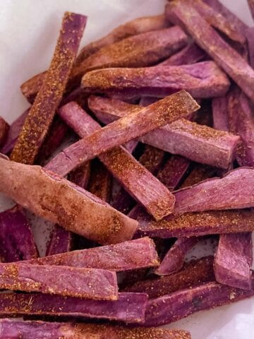 close up of Tex-Mex seasoned purple sweet potato fries on parchment paper