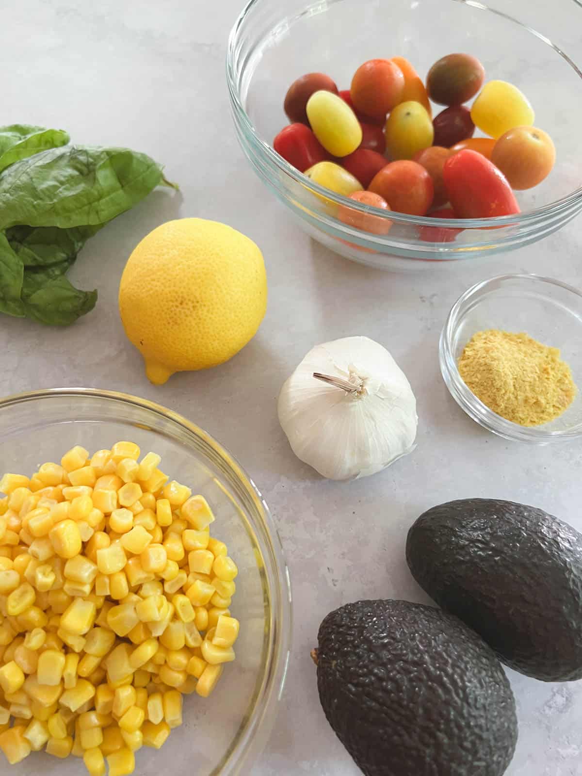 ingredients for creamy avocado basil pasta with tomatoes and corn