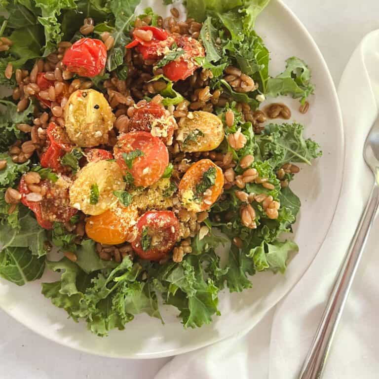 close up of a plate with farro and kale salad with blistered tomatoes