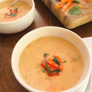 bowl of lightened-up Instant Pot corn chowder with bowl and cutting board in the background