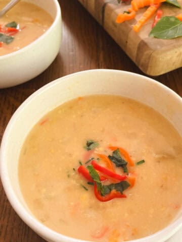 bowl of lightened-up Instant Pot corn chowder with bowl and cutting board in the background