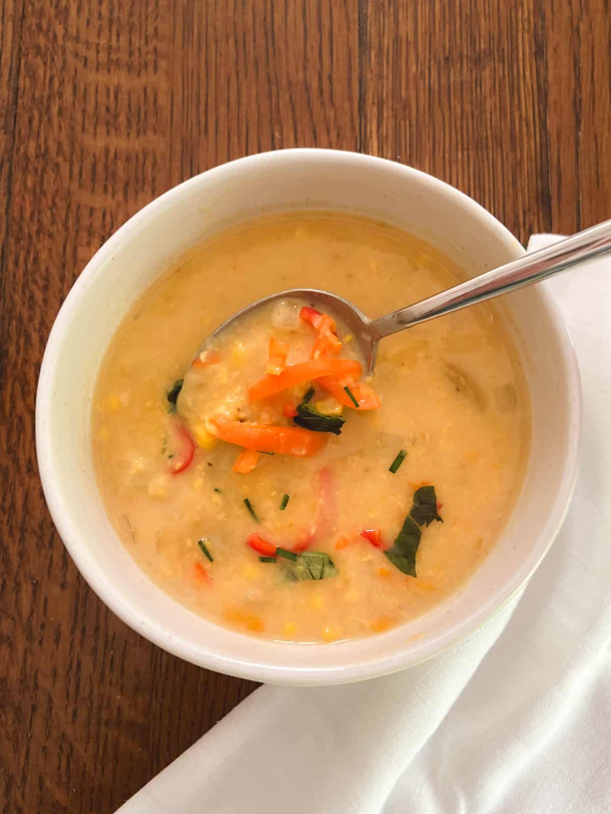 bowl containing lightened-up Instant Pot corn chowder with a spoon lifting out a spoonful