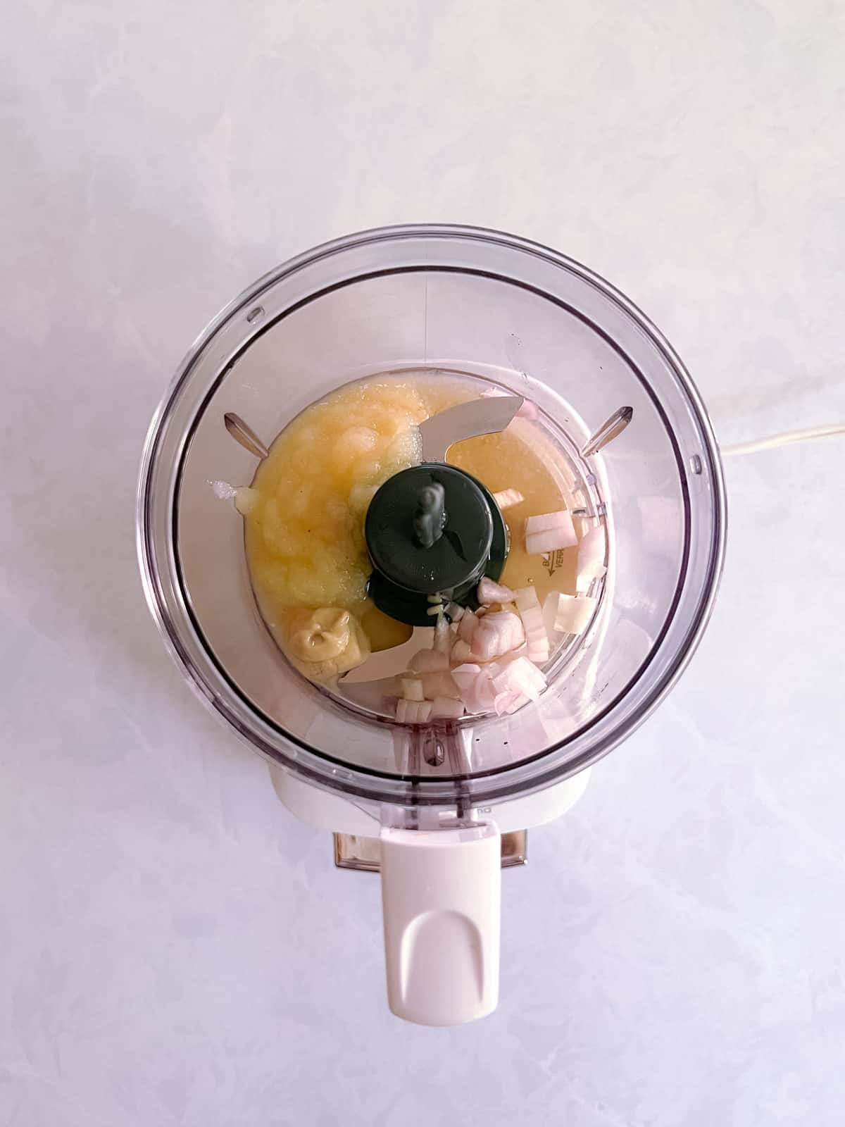 unmixed ingredients for champagne vinaigrette in a mini food processor