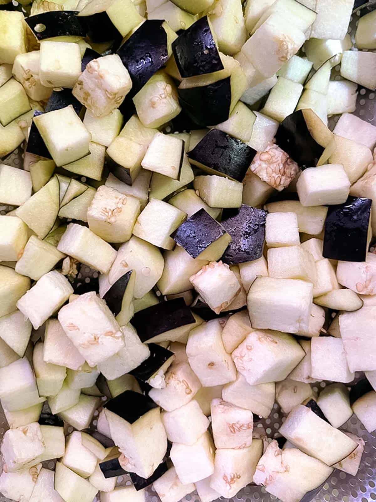 closeup of diced eggplant draining in a colander