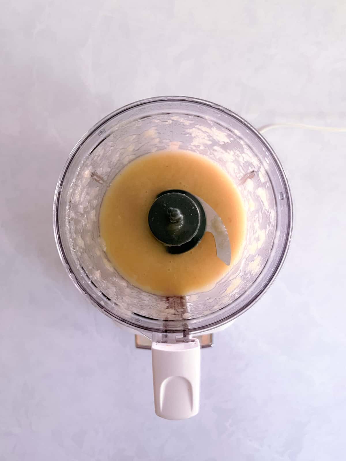 blended ingredients for champagne vinaigrette in a mini food processor