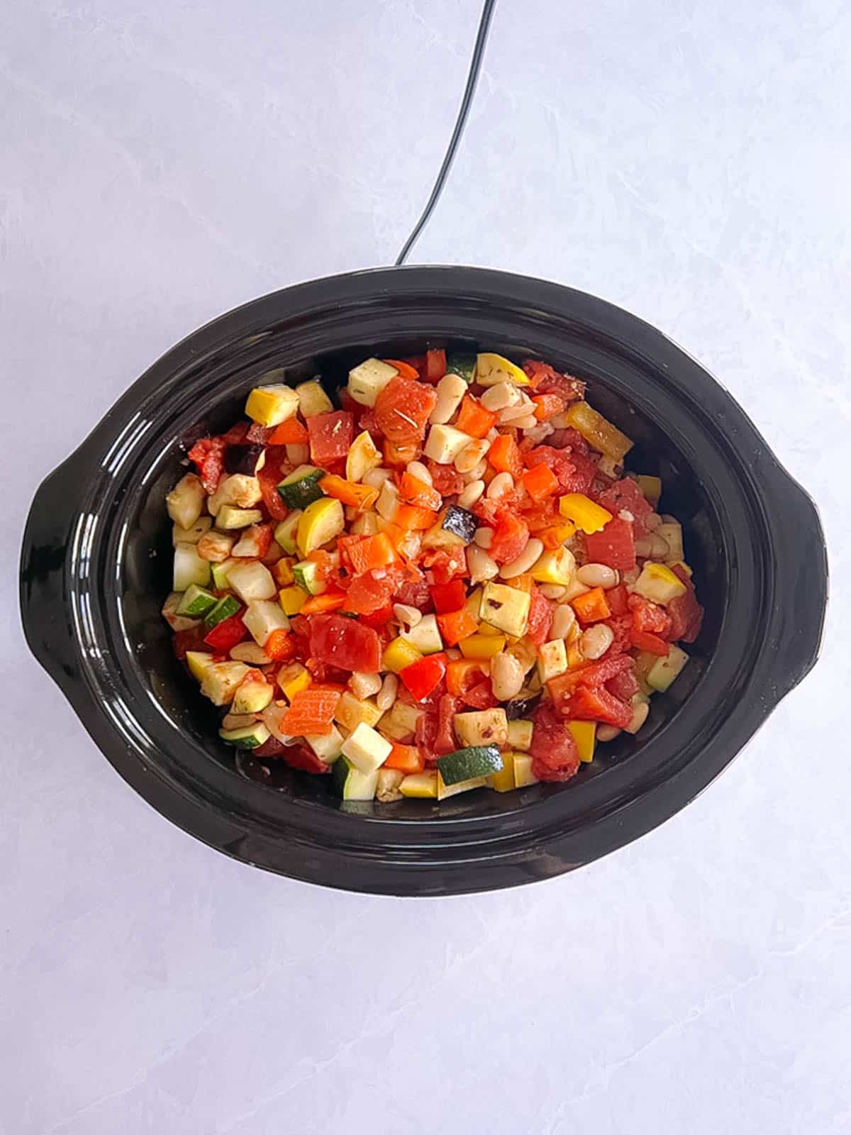 uncooked ingredients for slow cooker ratatouille with white beans in a slow cooker