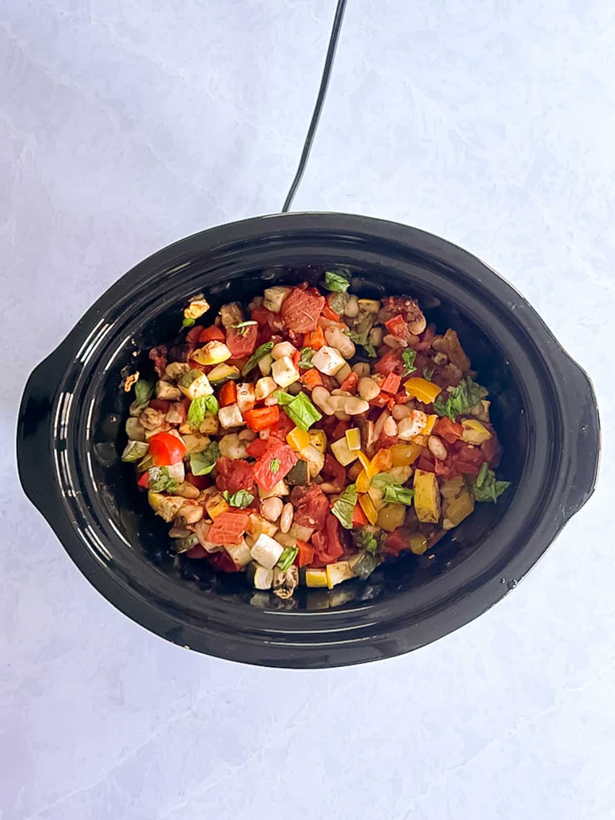 overhead of slow cooker containing cooked slow cooker ratatouille with white beans