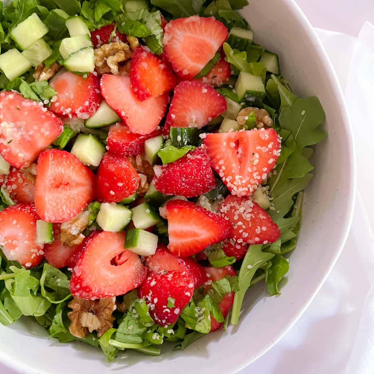 close up of bowl of strawberry basil salad with champagne vinaigrette