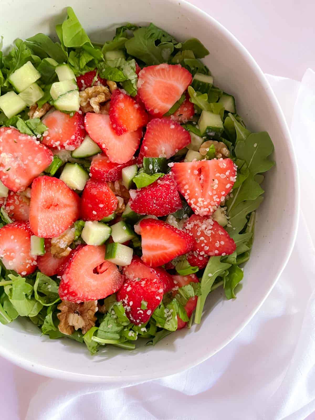 closeup of bowl of strawberry basil salad with champagne vinaigrette