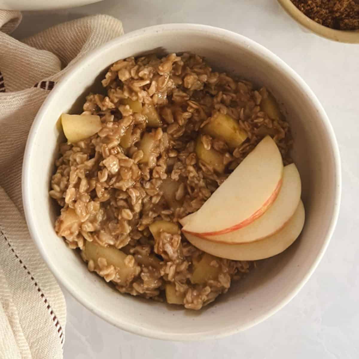 overhead of a serving bowl of one-pot apple cinnamon oatmeal garnished with apple slices