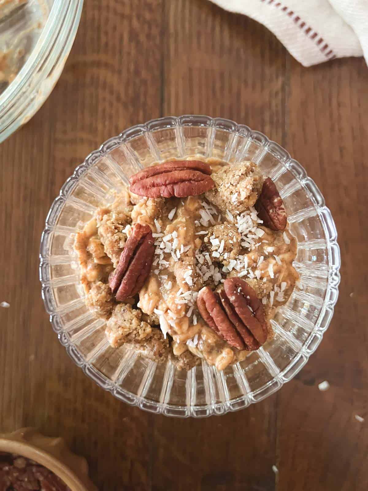 overhead view of a single serving of pumpkin spice overnight oats (without yogurt) topped with pecans and shredded coconut