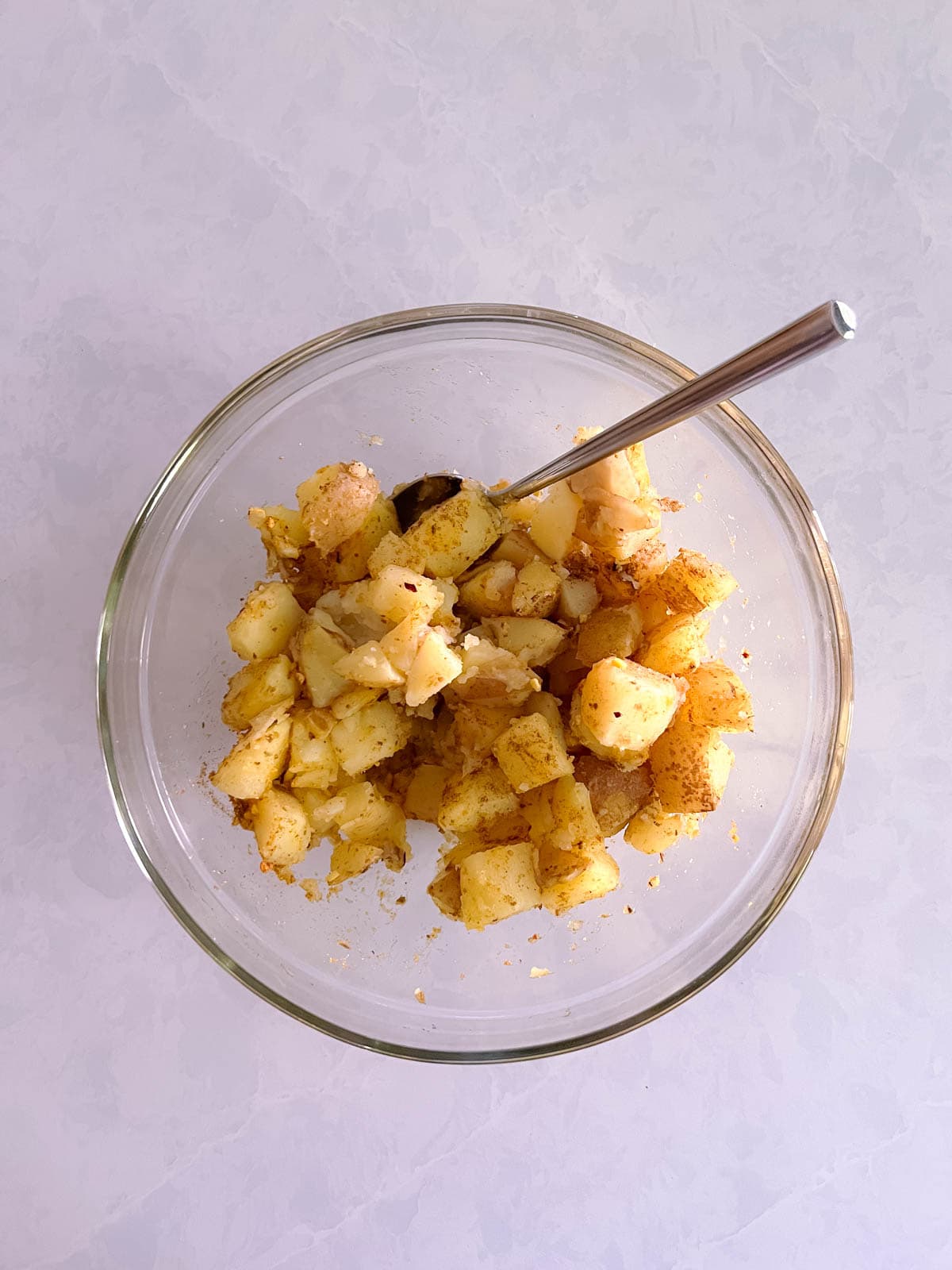 bowl of cooked potatoes with spices mixed in