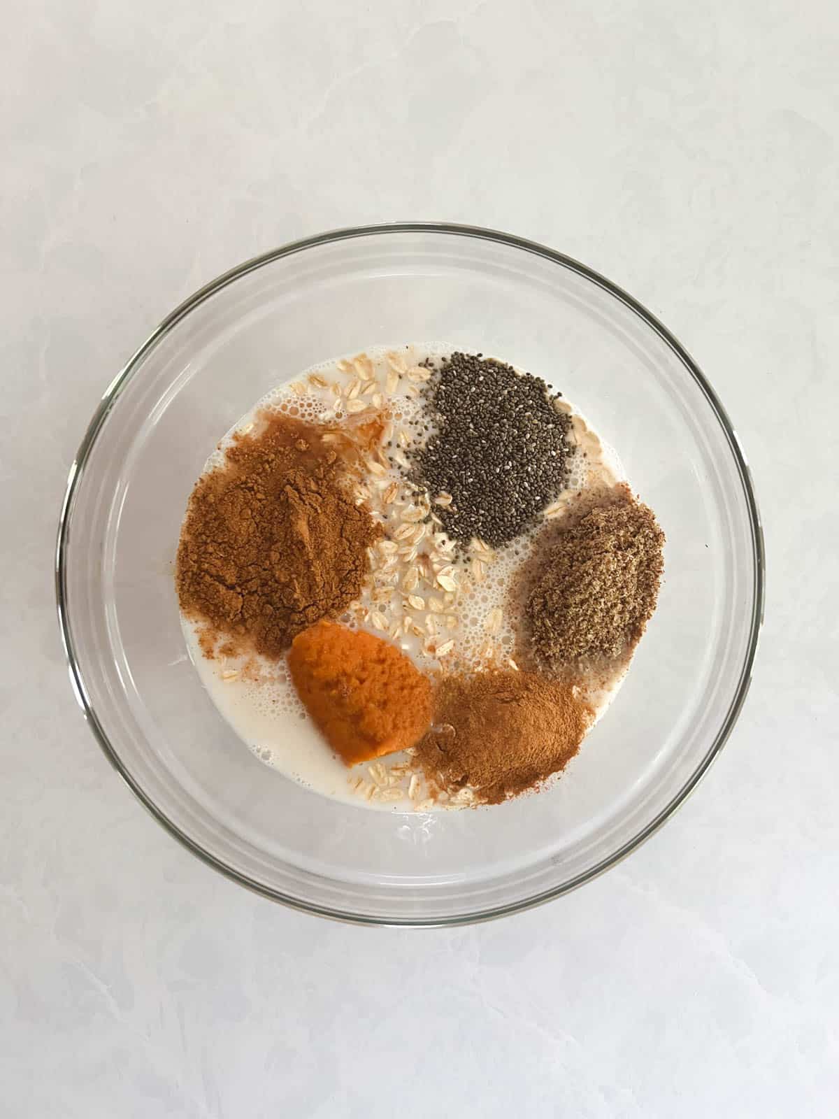 bowl of unmixed ingredients for pumpkin spice overnight oats (without yogurt)