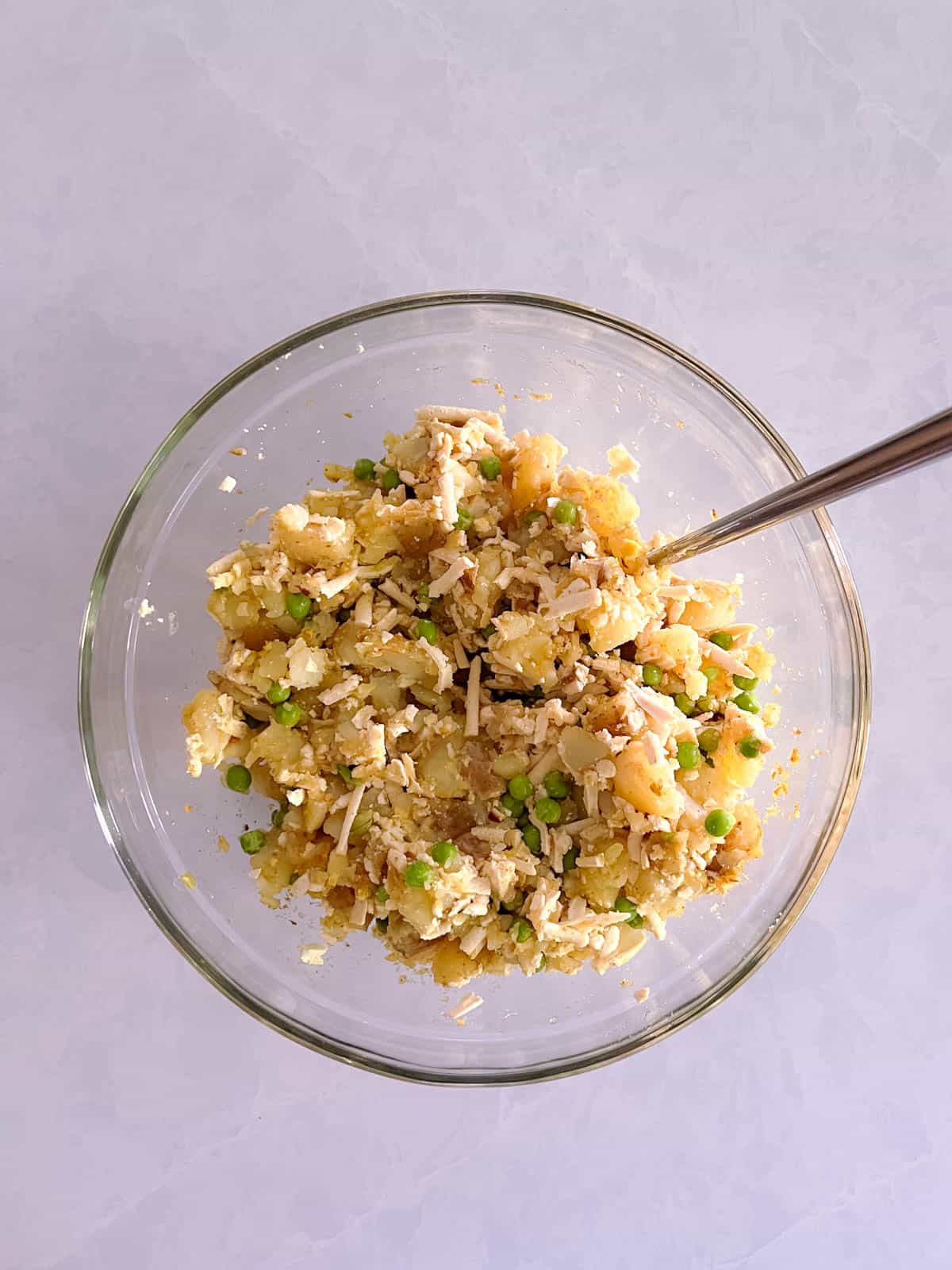 bowl of grated tofu and peas mixed with spiced potatoes