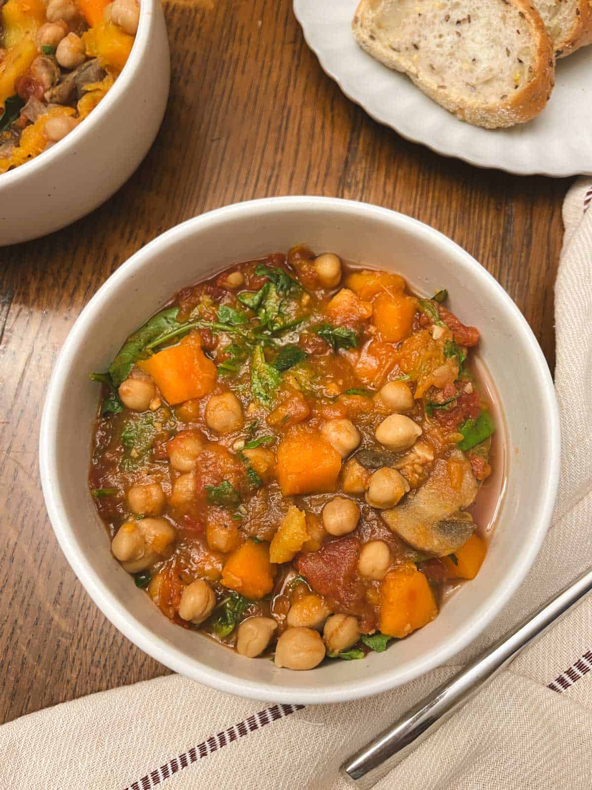 bowls of slow cooker fall harvest ratatouille with a plate of bread