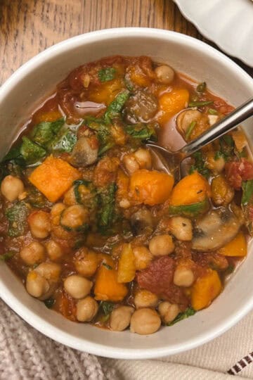 bowl of slow cooker fall harvest ratatouille held in a hand