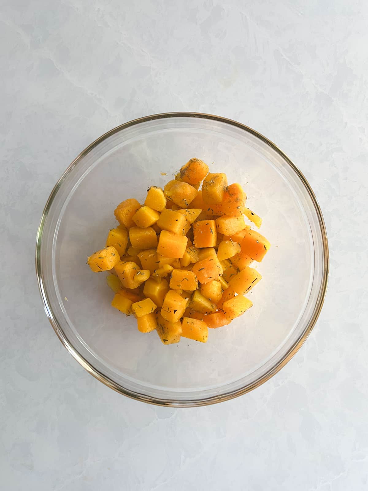 bowl of diced butternut squash tossed with spices