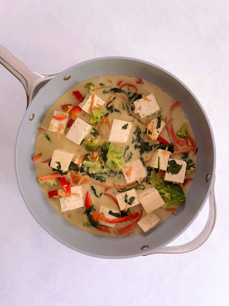 saute pan containing easy vegan green curry with tofu and vegetables