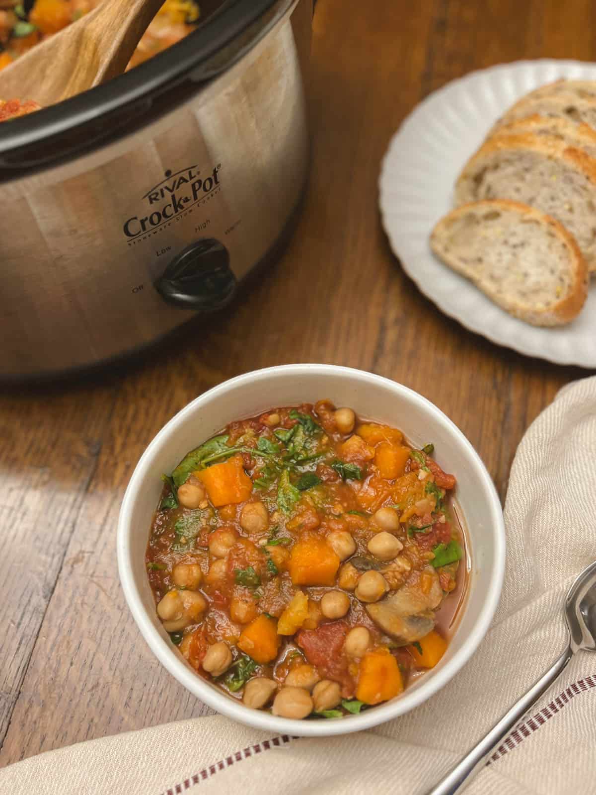 bowl of fall harvest ratatouille with crockpot and bread in the background