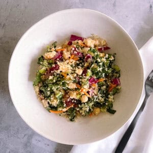 bowl of autumn quinoa salad with a black fork and white napkin