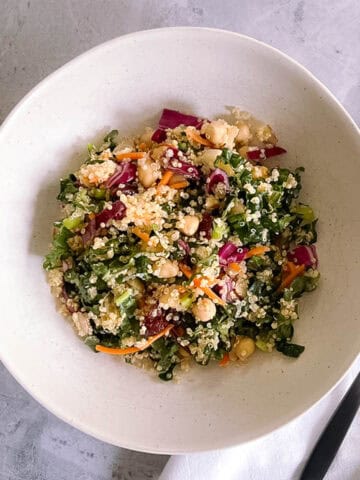 bowl of autumn quinoa salad with a black fork and white napkin