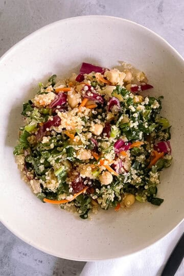 bowl of autumn quinoa salad with a black fork and white napkin