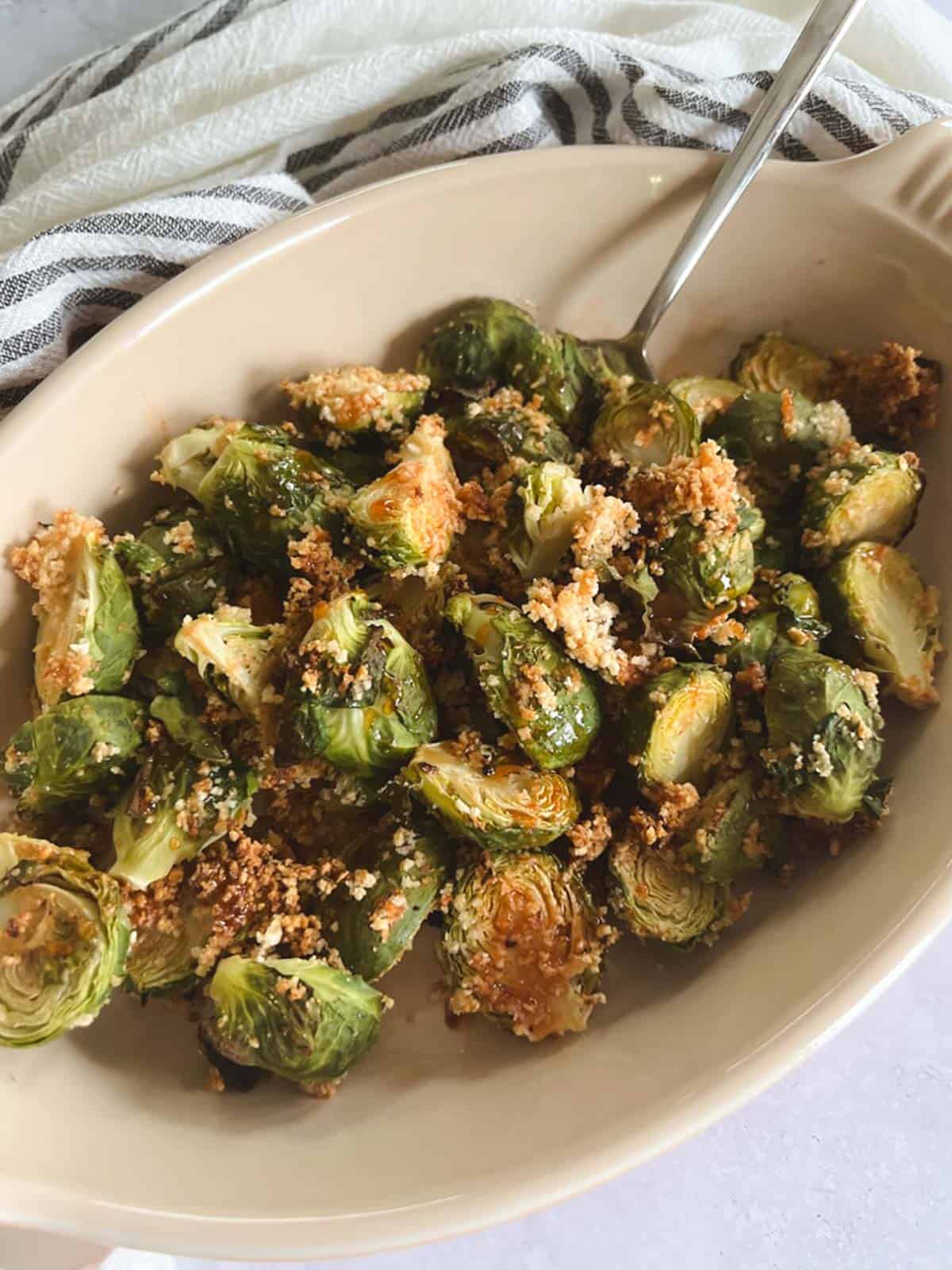 closeup of serving dish of crispy brussels sprouts with spicy maple syrup