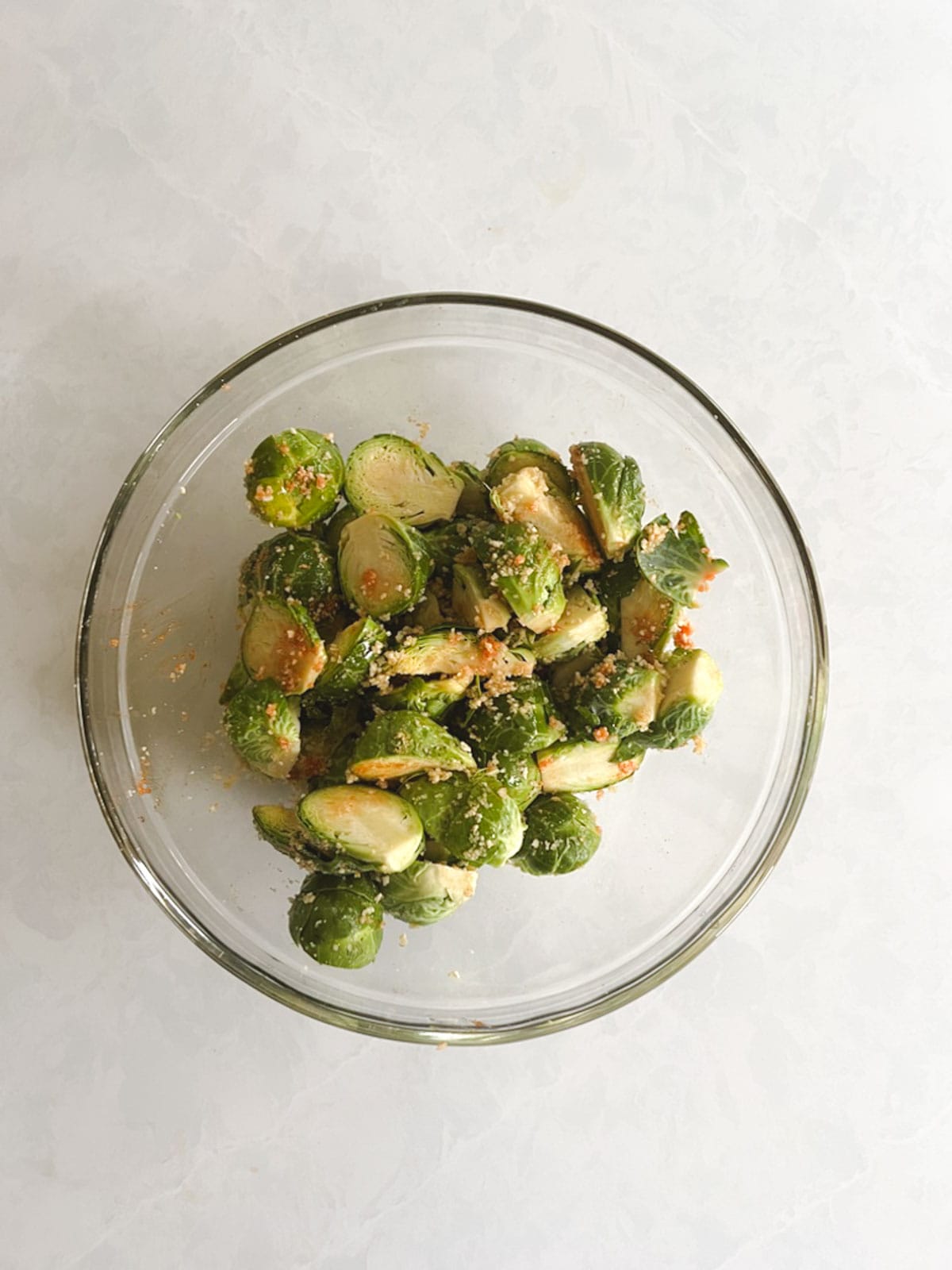 overhead of bowl of brussels sprouts tossed with toppings