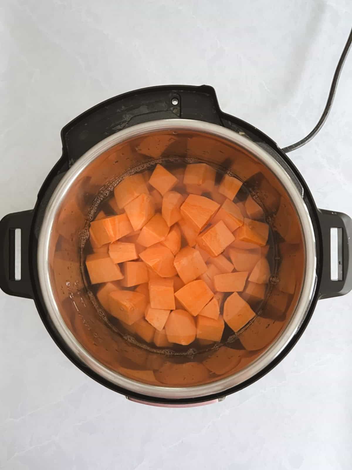 overhead view of instant pot containing chopped potatoes and water