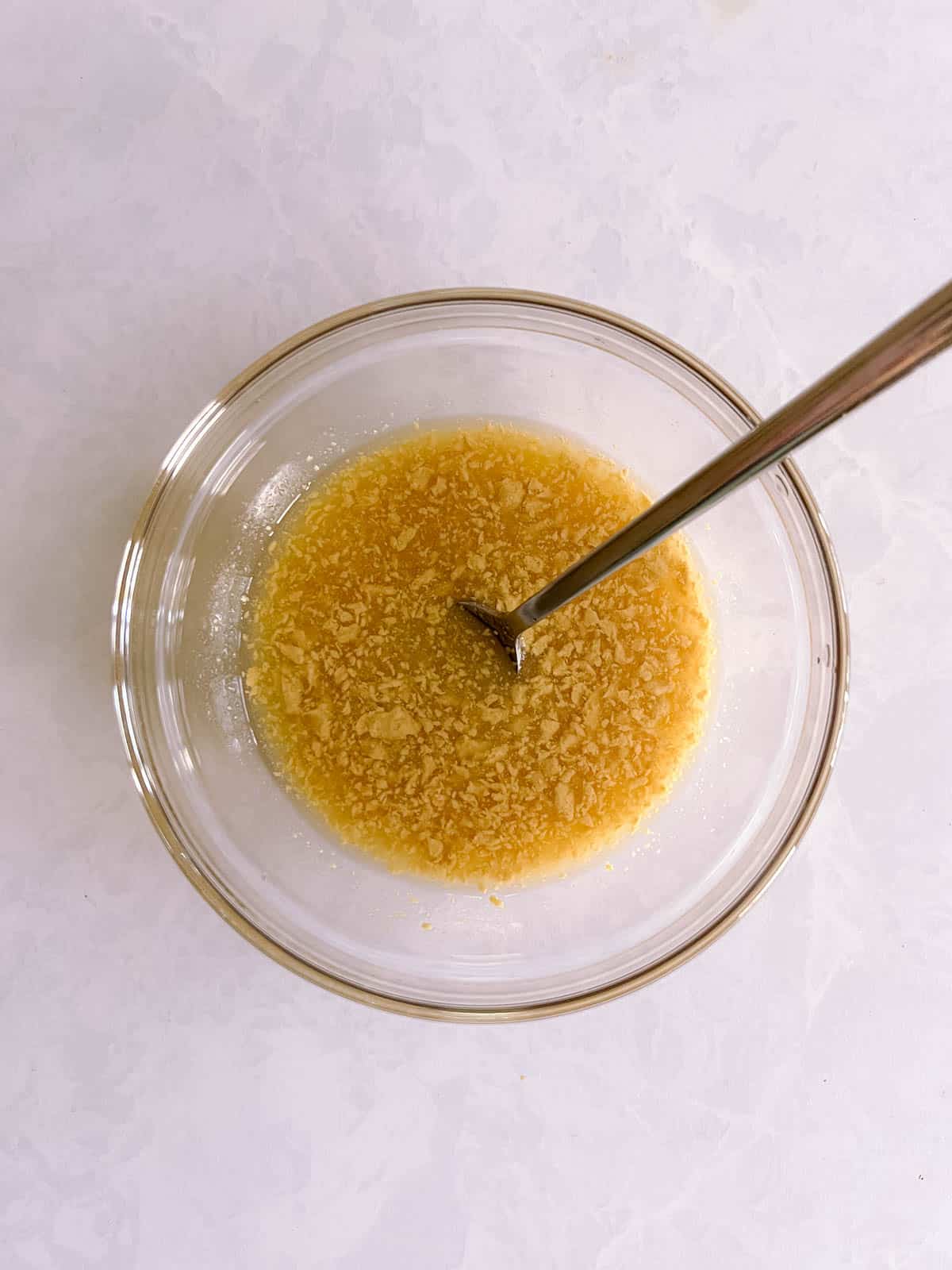 glass bowl of apple cider vinaigrette with fork in it