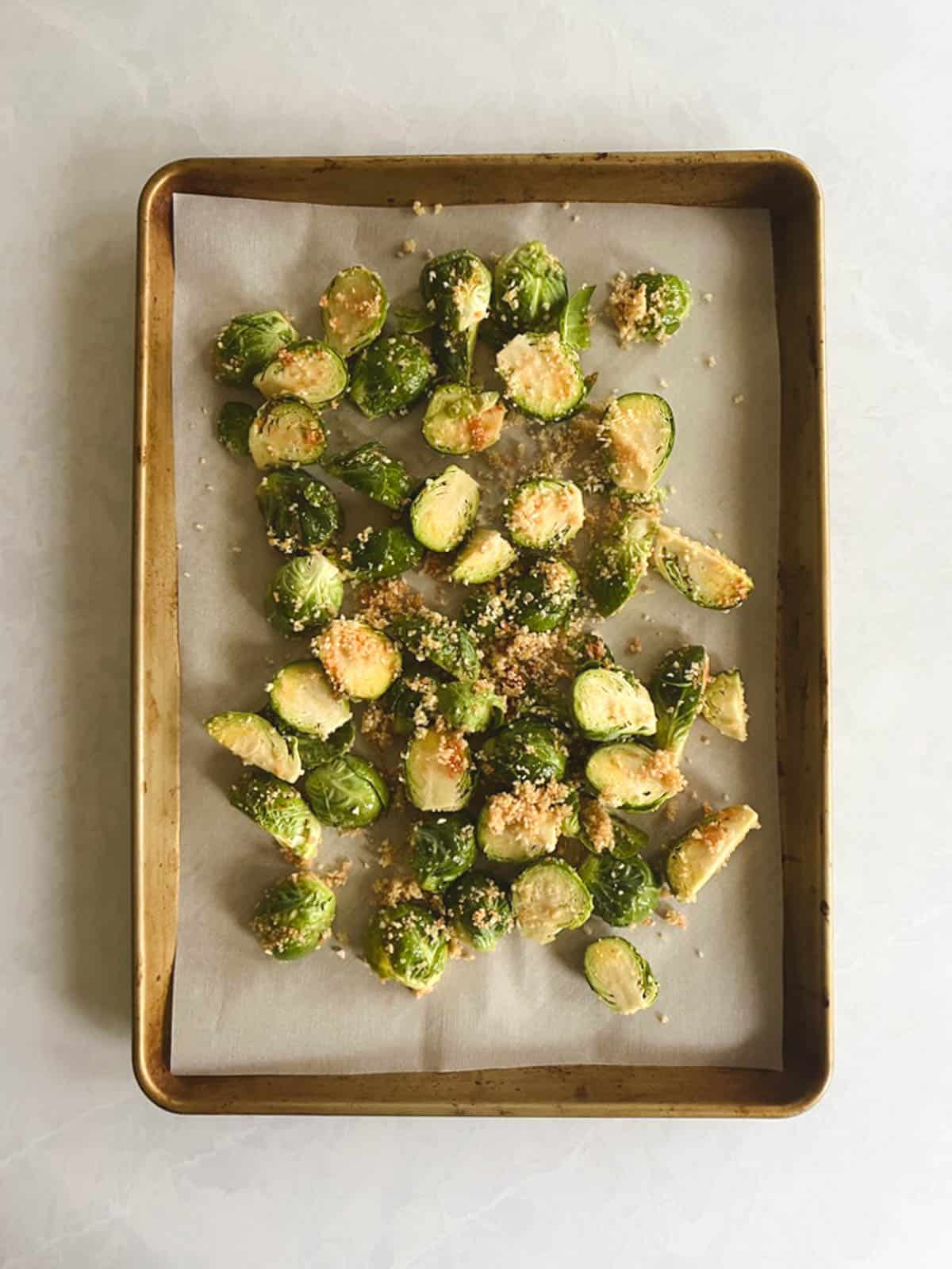 overhead of prepared baking sheet containing brussels sprouts with topping