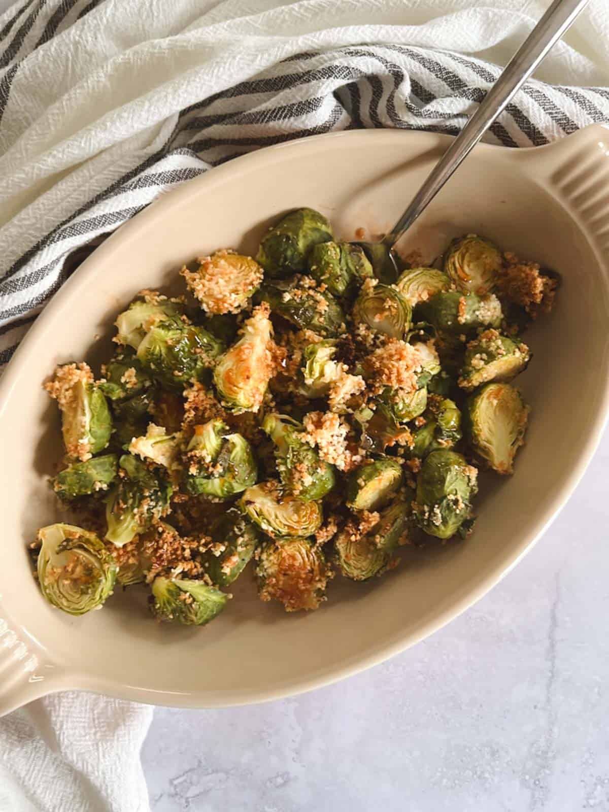 serving dish of crispy brussels sprouts topped with spicy maple syrup