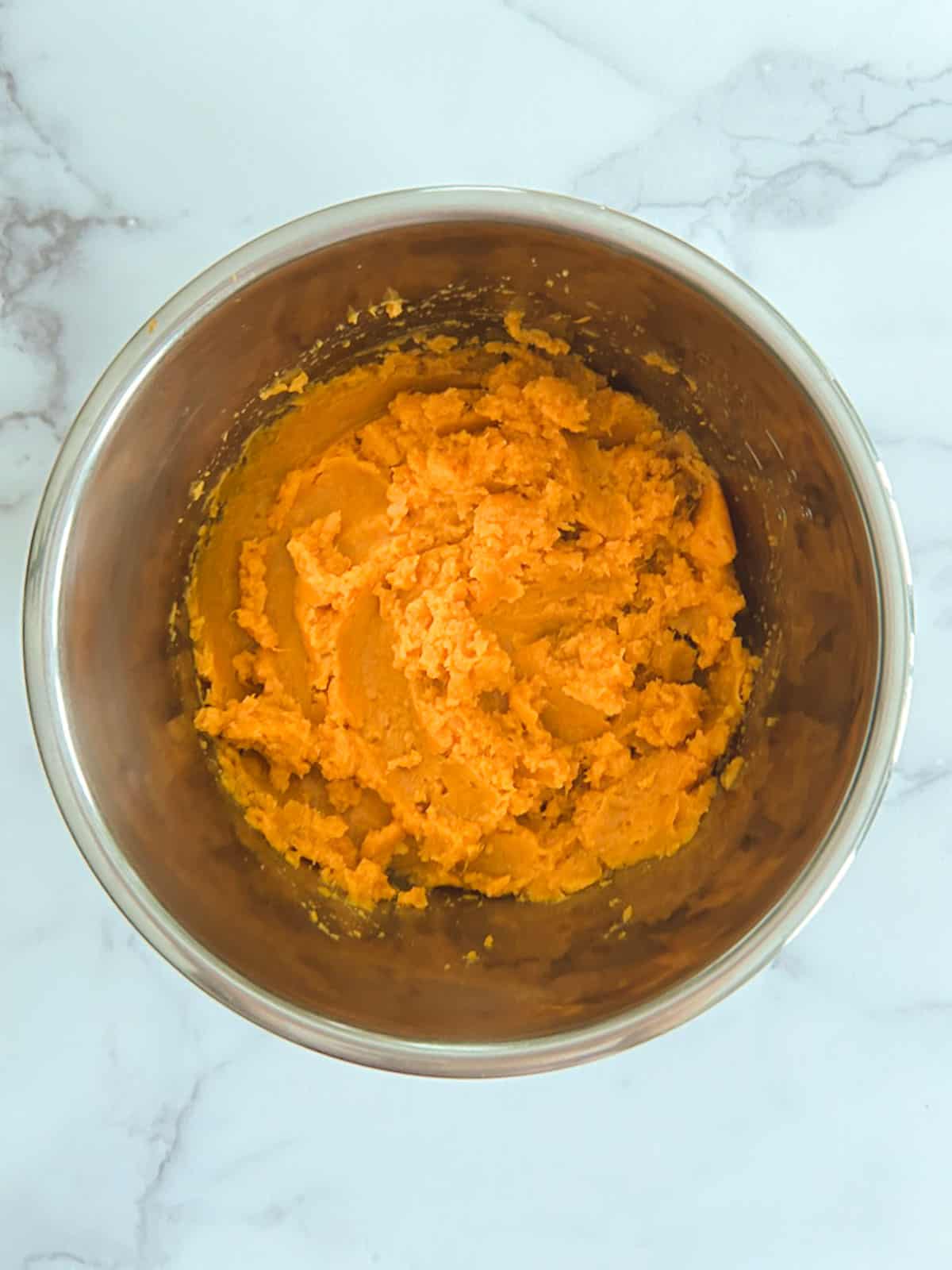 overhead view of instant pot inner pot containing mashed sweet potatoes