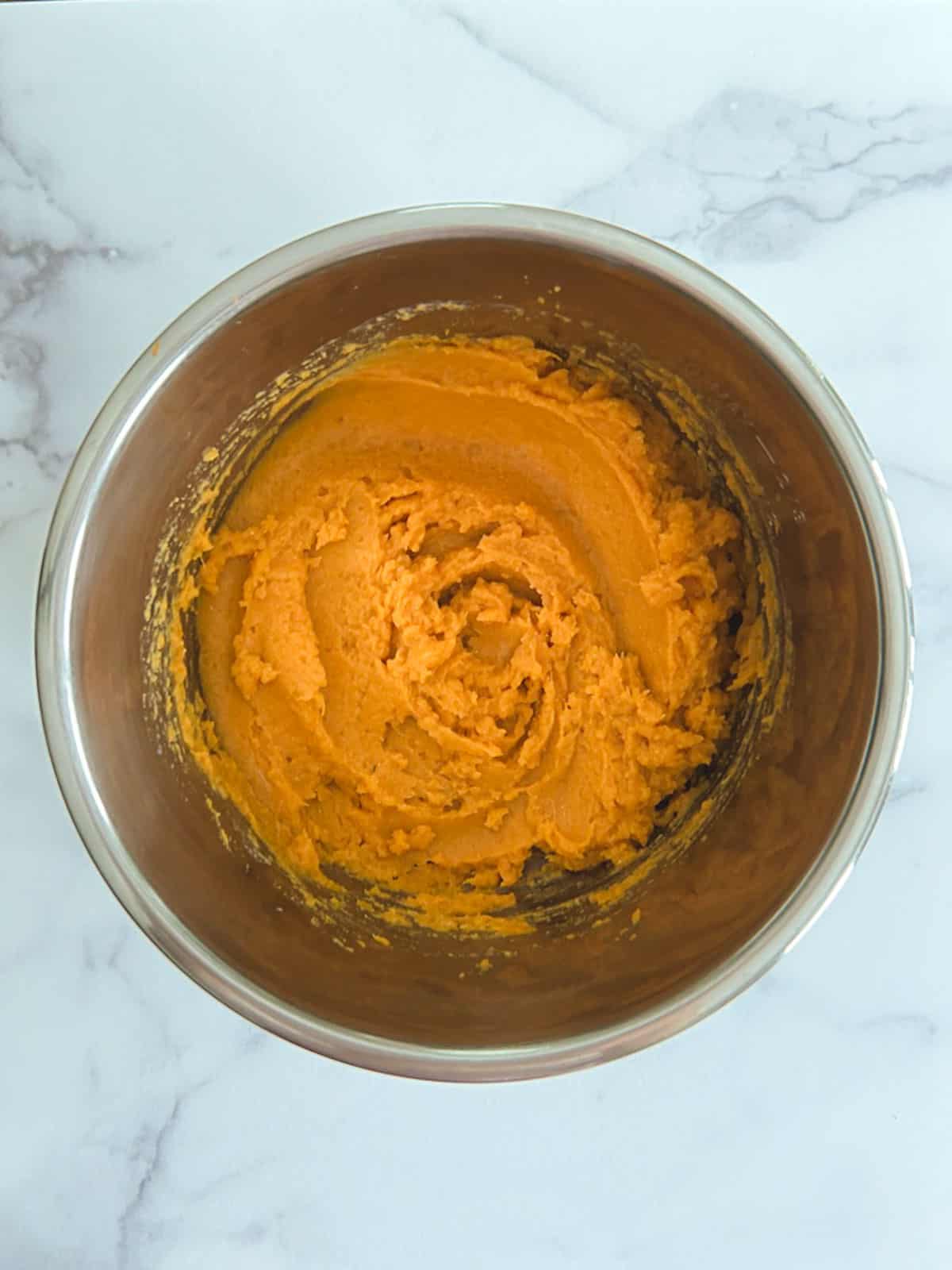 overhead view of inner pot containing mashed sweet potatoes with miso-maple swirl ingredients fully incorporated